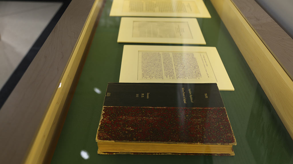 documents and a book in display case
