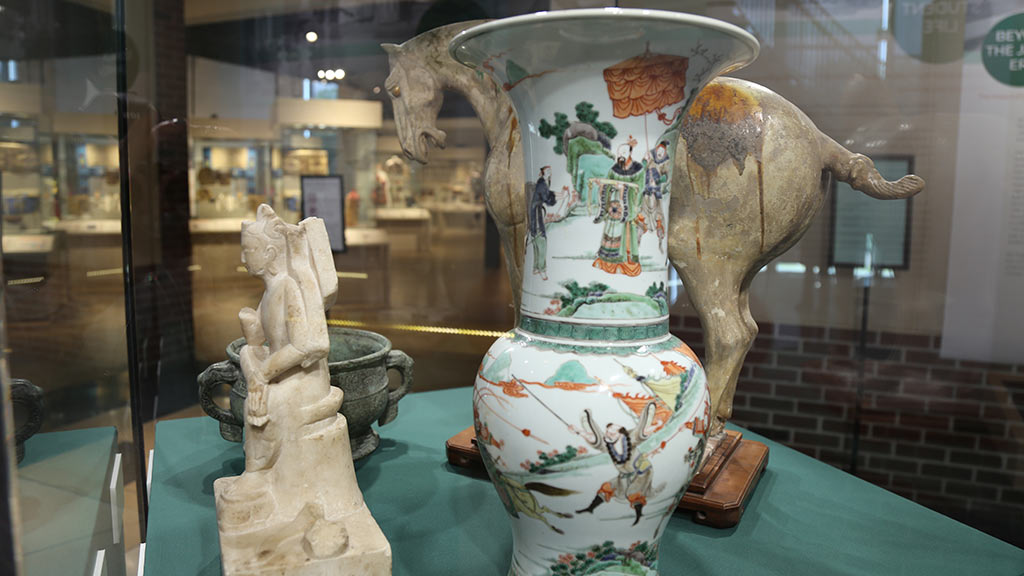 sculpture of chinese god and china pottery with an animal statue in the back