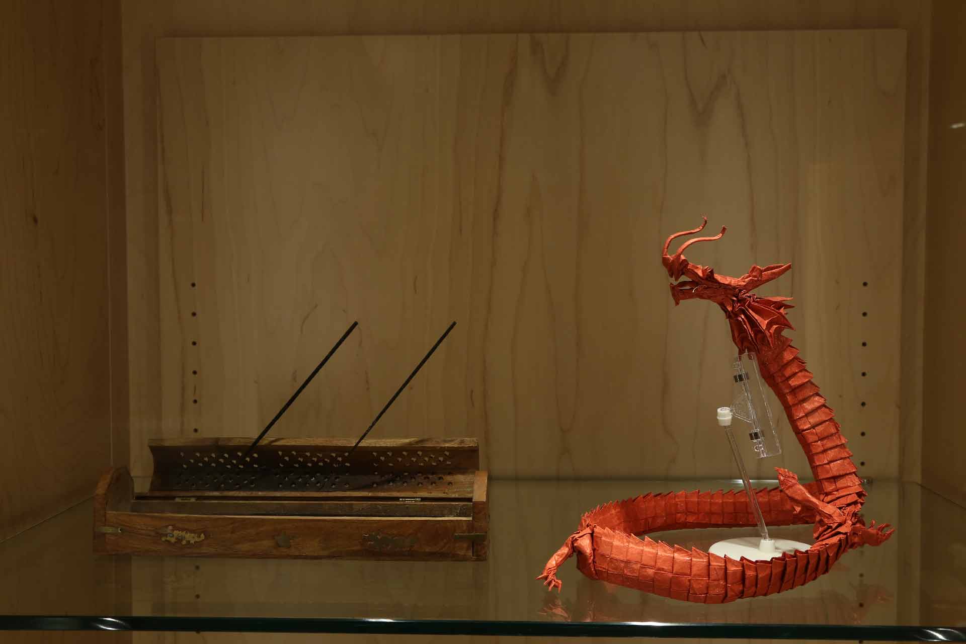 a small brown case and red dragon resting on a platform