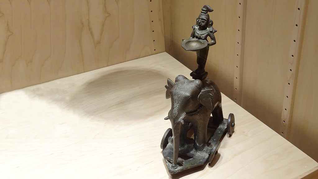bronze sculpture of a woman holding a plate standing on an elephant