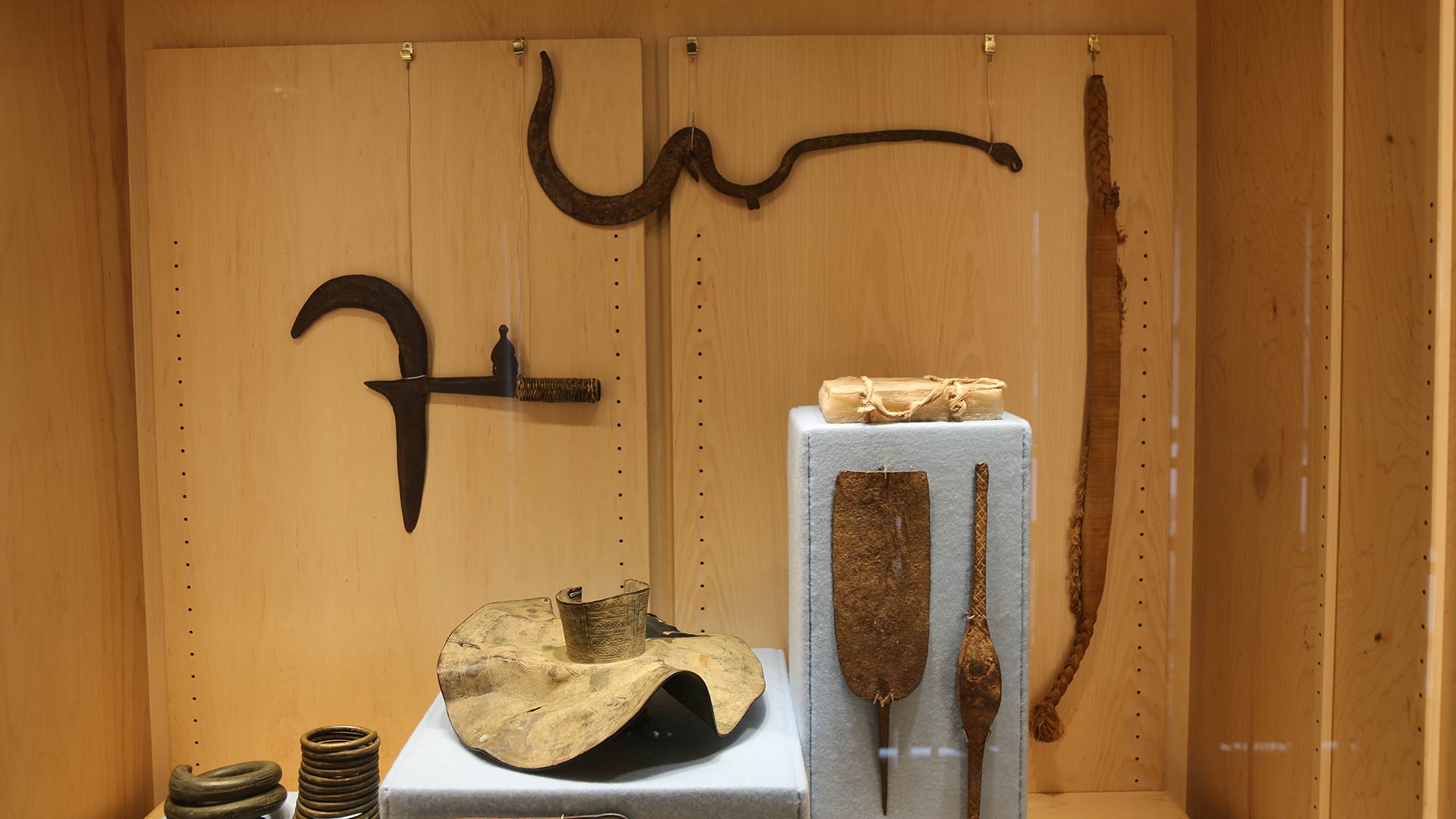 artifacts overview showing all the artifacts in a case with some longer pieces of metal not shown before, presumably weapons
