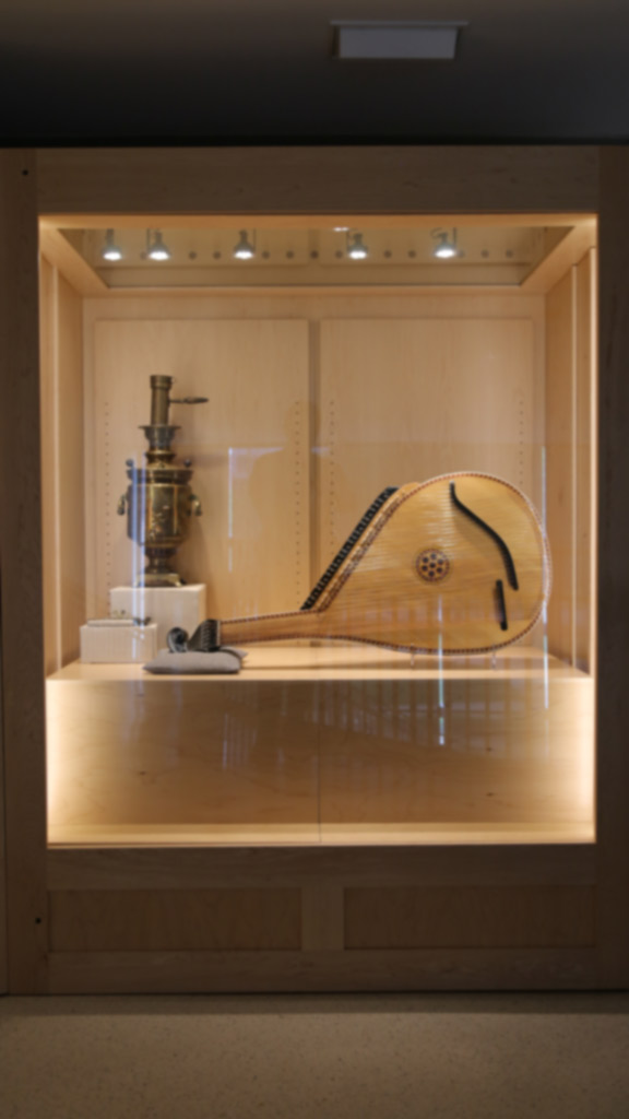 shot of the right case containing the stringed instruent, spoon-like apparatus, and a metal machine