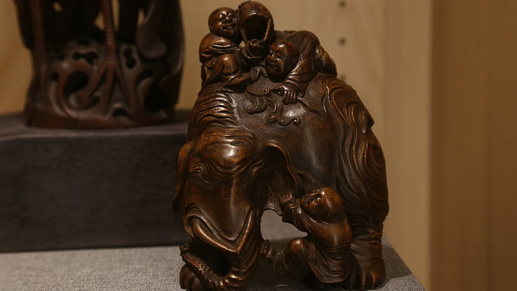 close-up of a sitting figure that has babies crawling on them