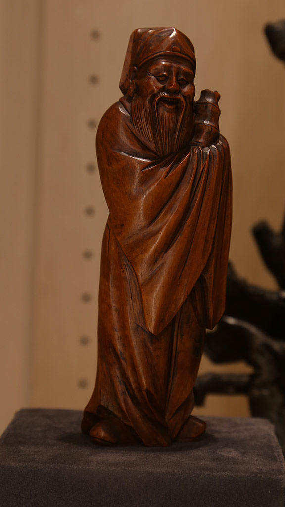close-up of a smiling robed man holding an object