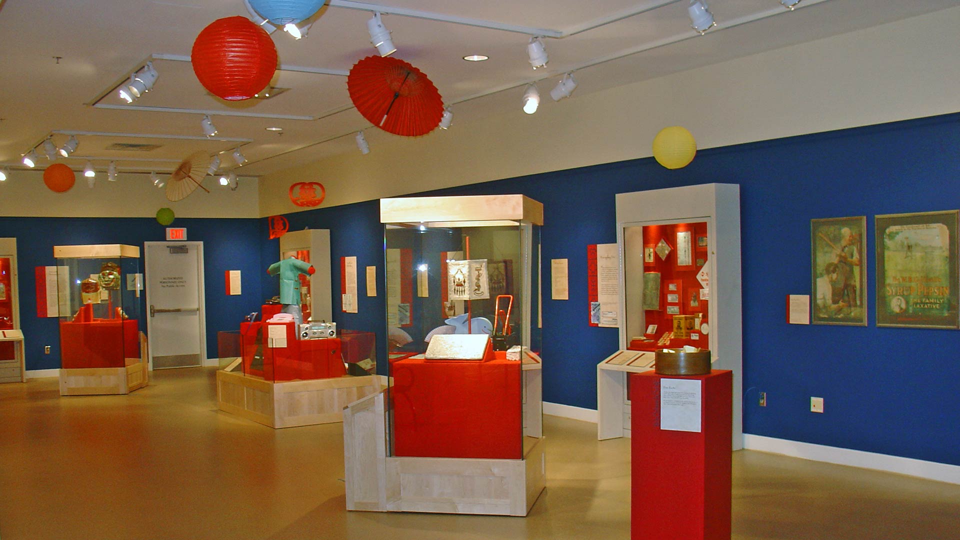 gallery overview, red paper lantern and umbrella, ocean blue walls, display stands