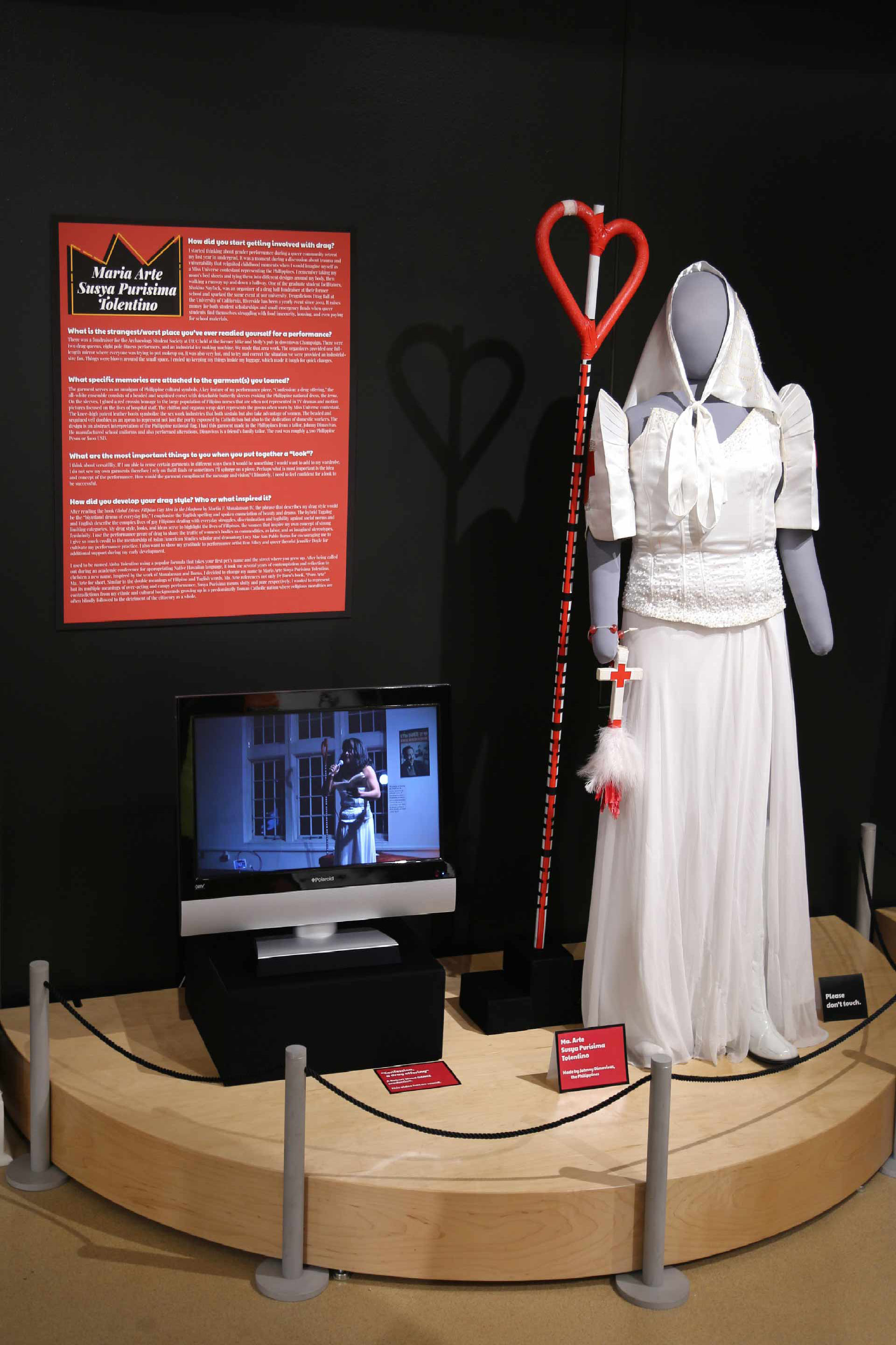 Mannequin in nurse drag costume display next to TV displaying video