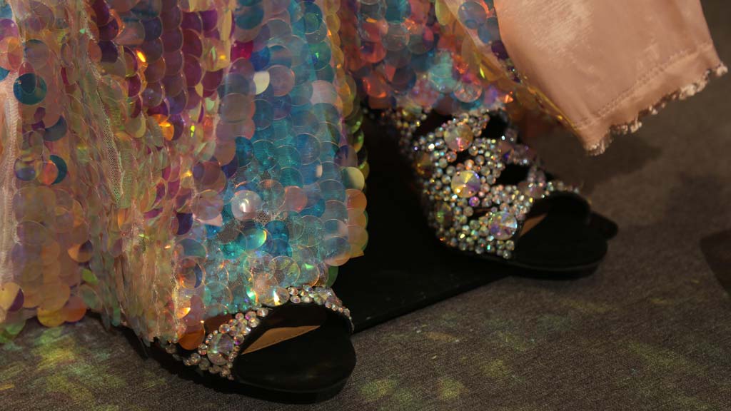 closeup of bottom of sequined costume and rhinestone covered shoes