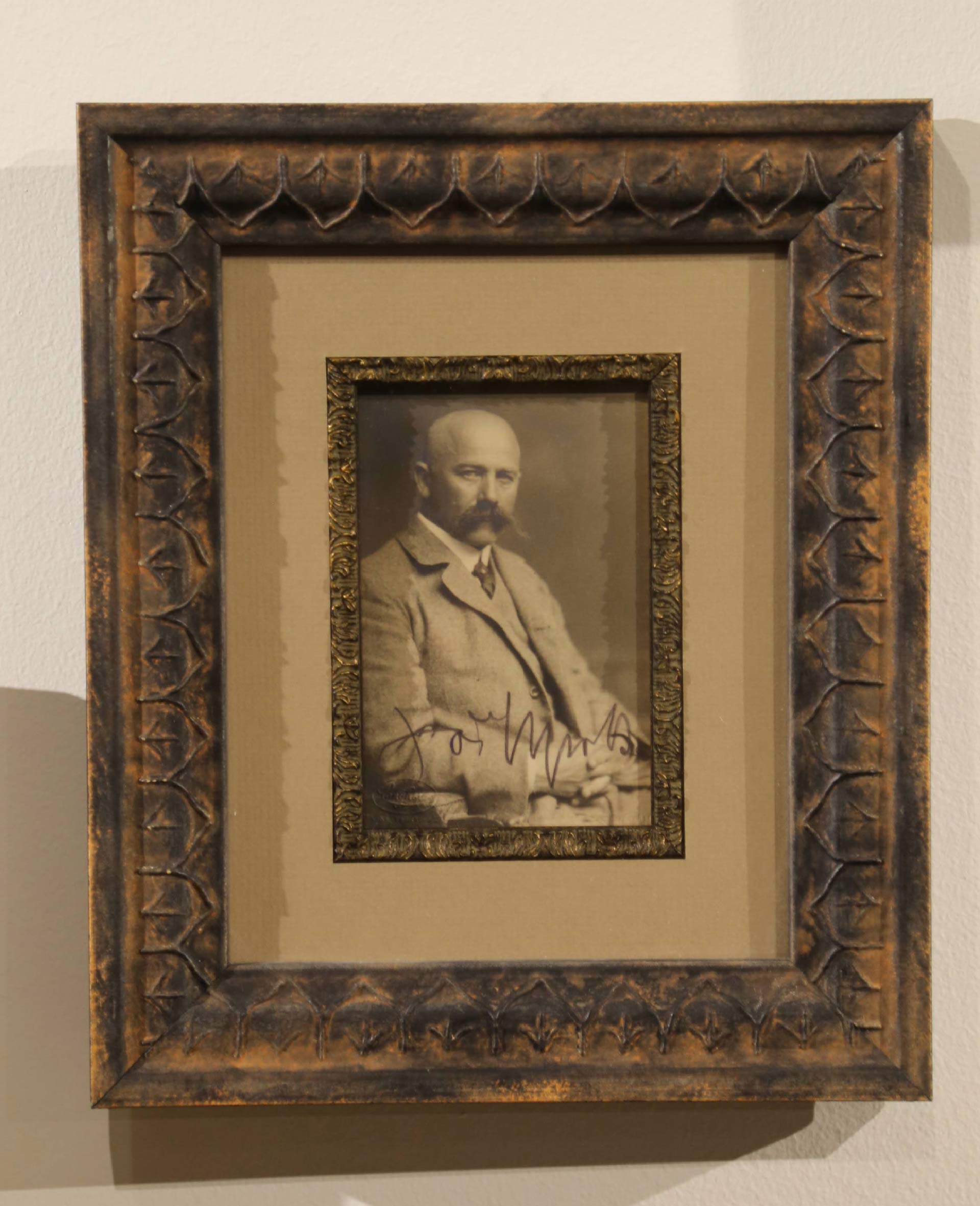 painting of a man with a moustache and crossed hands
