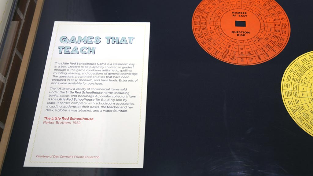 text card with the title 'games that teach' in a display case