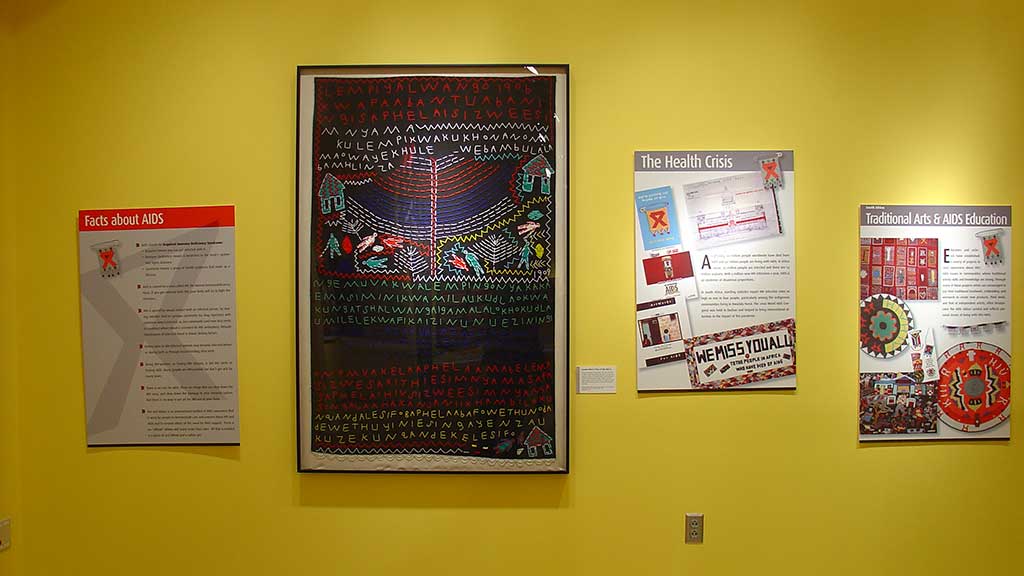 woven figure with intricate embroidery and letters