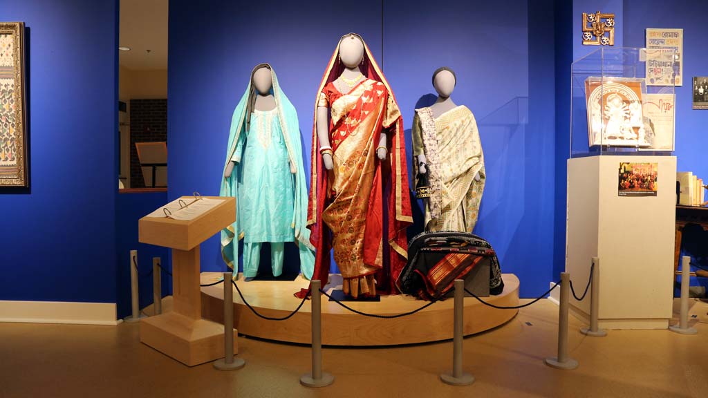 several mannequins wearing teal, red and gold, and white clothing