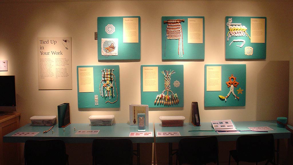 another shot of the colorful knots wall with a text card with the heading 'tied up in your work'